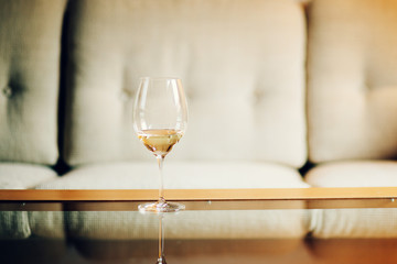 Glass with white wine with blurry background, quiet evening of a hard day