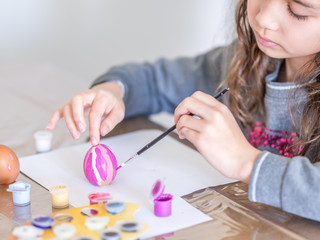 Enfant peignant des oeufs pour Pâques 