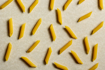 pattern of raw italian pasta on brown background