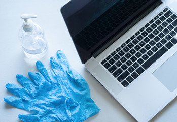 Pandemic work kit on white office desk with hand sanitizer, face mask and gloves. Corona virus...