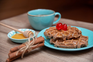 Healthy breakfast waffles with honey and coctail cherries