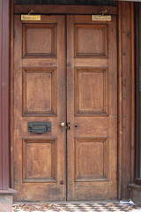 a close up view of a old double wooden door leading into a urban building