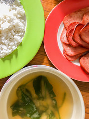 Plates of rice and fried luncheon meat and a bowl of miso soup.