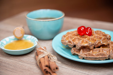 Healthy breakfast waffles with honey and coctail cherries