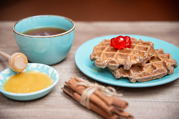 Healthy breakfast waffles with honey and coctail cherries