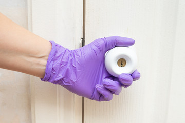hand holds door handle in latex glove