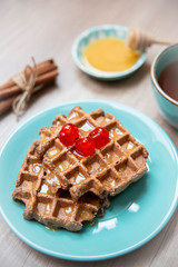Healthy breakfast waffles with honey and coctail cherries