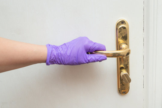 Hand Holds Door Handle In Latex Glove