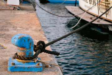 Rusty Blue Mooring Bollard With Ship Ropes