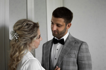 morning of the bride and groom. the bride helps to dress the groom on the wedding day. selective focus.film grain.