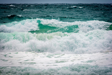 Turquoise colour ocean wave in windy day.