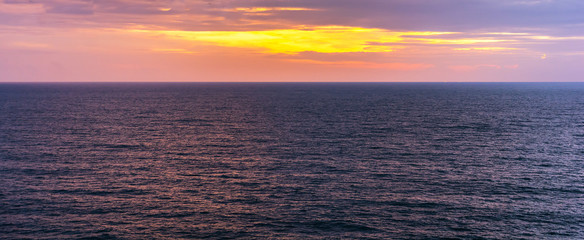 Fototapeta premium Vivid color sunset sky with cloud at the sea.