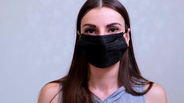 Female patient in a black protective mask looks at the camera. Hygiene concept. prevent the spread of germs and bacteria and avoid infection with the crown virus