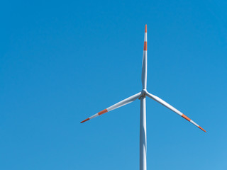 Wind turbine with clear blue sky background. Renewable energy source.