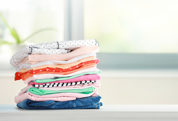 Stack of cotton colorful clothes,folded clothing on table empty space.