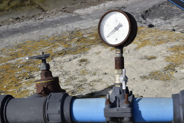 Air pressure sensor on compressor and iron tap on blue plastic pipe.