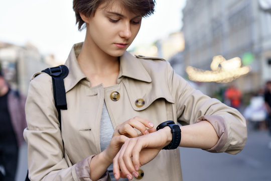 Fashion Hipster Millennial Teen Girl Traveler Using Wrist Smart Watch Walk On Urban City Street. Young Woman Traveler Look At Smartwatch Digital Modern Tech App Concept Outdoor Lifestyle. Closeup.