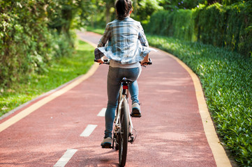 Naklejka premium Woman cyclist riding mountain bike in park
