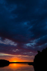 See umgeben von Wald bei Sonnenuntergang am späten Abend	