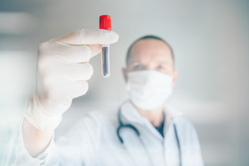 Doctor holding blood test. Pandemics outbreak crisis. Blood sample in a tube at lab. 