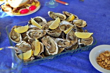 Oysters with lemon on a table blue background.from Nantes france