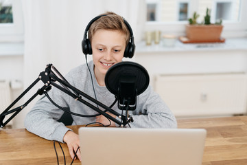 Teenager sitting at computer with professional mic