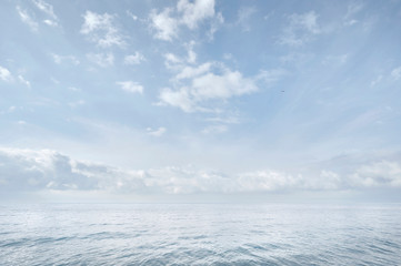 Blue sea and sky. White clouds. Hardly visible horizon line. Seascape