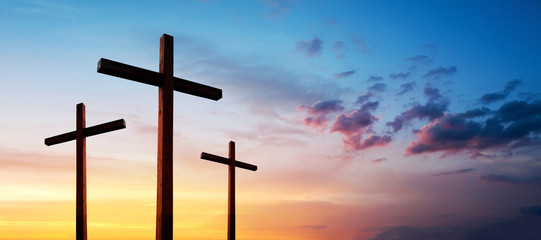 Cross of Jesus Christ empty over dramatic sunrise sky panorama with sclouds.  Easter concept