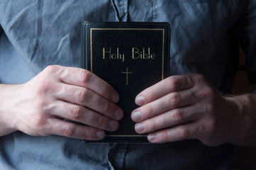 The Bible is in the hands. Bible on the chest. Priest man