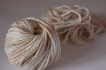 a  wool ball for knitting of light pale pink and beige colors