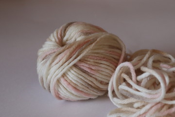 a  wool ball for knitting of light pale pink and beige colors