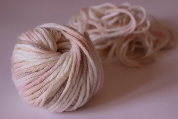 a  wool ball for knitting of light pale pink and beige colors