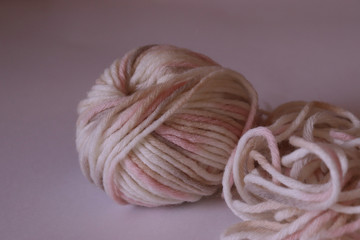 a  wool ball for knitting of light pale pink and beige colors
