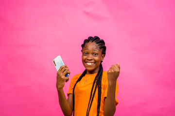 young black beautiful lady happy over something on her smartphone