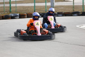 girl is driving Go-kart car with speed in a playground racing track.