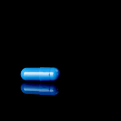 Blue pill isolated on black background