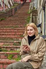 Fototapeta premium Young woman on a walk is studying map on phone.