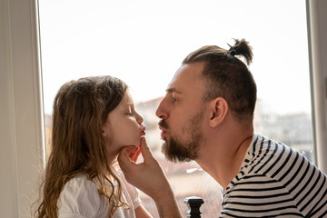father and little daughter kissing
