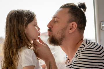 father and little daughter kissing