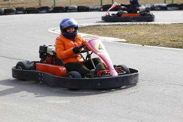 Fototapeta premium girl is driving Go-kart car with speed in a playground racing track.