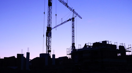 Construction site with cranes at nightfall