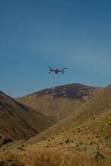 Fototapeta na wymiar A Small Drone Hovers Above a Remote Valley in Scotland