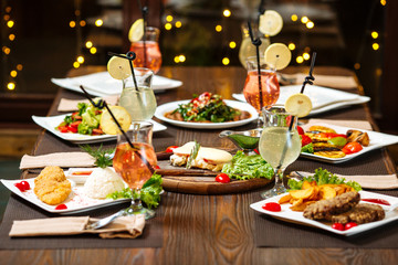 Festive dinner, served table, cocktails, delicious dishes, side view, horizontal