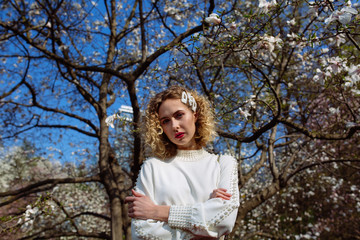 Woman portrait in white blouse in magnolia garden