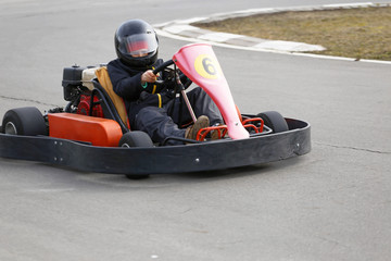 Fototapeta premium boy is driving Go-kart car with speed in a playground racing track.