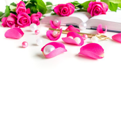 Lifestyle flat lay: White pearls, pink roses, petals, golden key and open book on clean white background. Mock-up. Copy space.