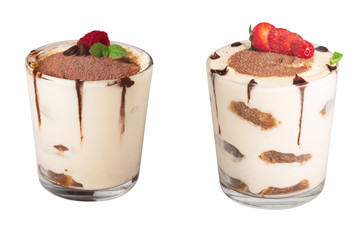 tiramisu in a glass with berries, mint and coffee beans on a light wooden background