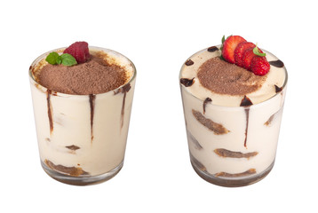 tiramisu in a glass with berries, mint and coffee beans on a light wooden background