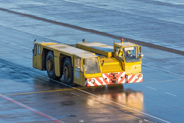 Aerodrome tow tractor is driving along the steering paths at the airport.