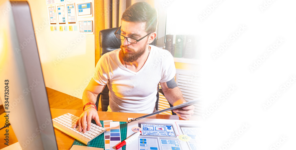 Poster ux design. man in a design studio. young guy works as a designer. application development for phones